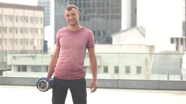 Man innehav hoverboard och ler. — Stockvideo