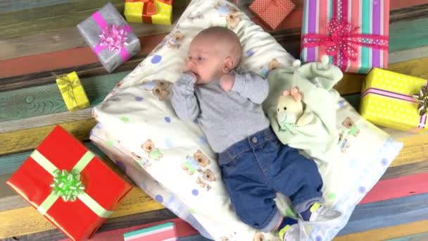 Baby und bunte Geschenke. — Stockvideo