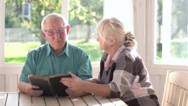 Пара літніх людей читає книгу . — стокове відео