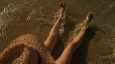 Genç kadın şapkalı, deniz kıyısı.