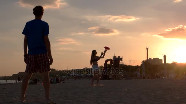 Glada sällskap spela frisbee på stranden. — Stockvideo