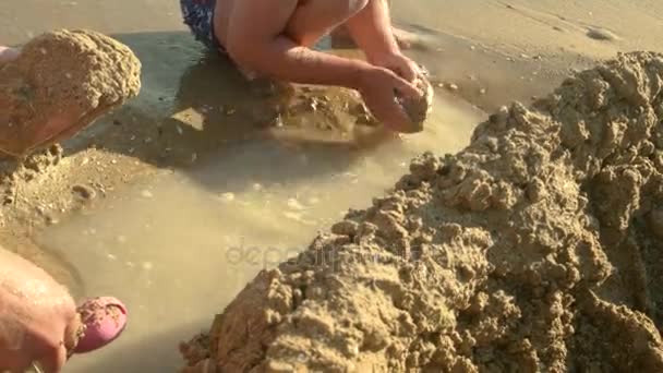 Hände spielen mit nassem Sand. — Stockvideo