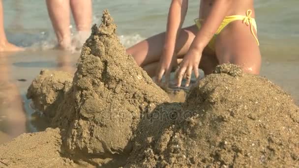 Kinder bauen eine Sandburg. — Stockvideo