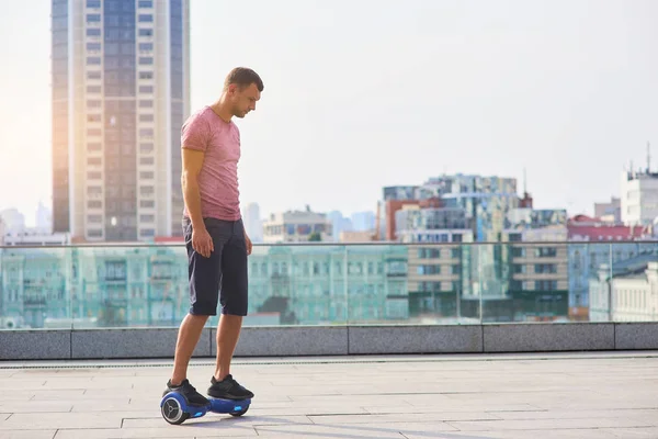 Mann reitet Hoverboard, Stadt Hintergrund. — Stockfoto