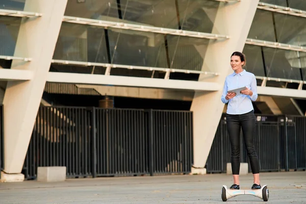 Kobieta z tabletu jazda hoverboard. — Zdjęcie stockowe