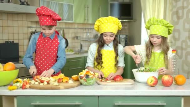 Three kids making salad. — Stock Video