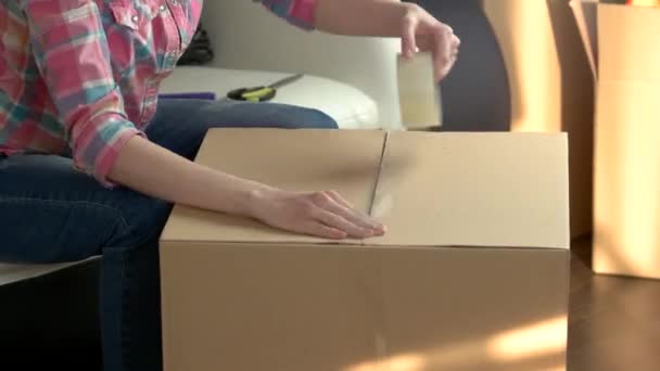 Женщина быстро упаковывает коробку . — стоковое видео
