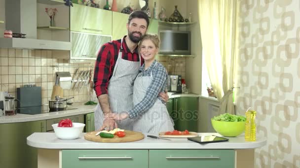 Pareja cerca de la mesa de cocina sonriendo . — Vídeos de Stock