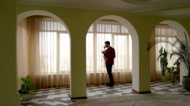 Pencere gül tutan adam.