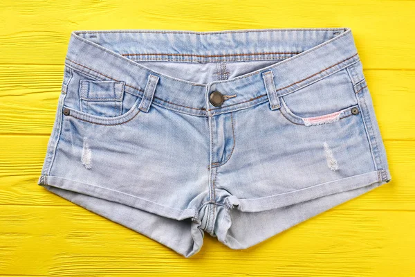 Jeans Shorts auf gelbem Hintergrund. — Stockfoto