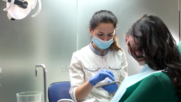 Dentista sosteniendo los dientes carta de color . — Vídeos de Stock