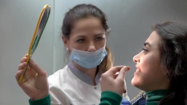 Zubař s pacienty hospodářství zrcadlo. — Stock video