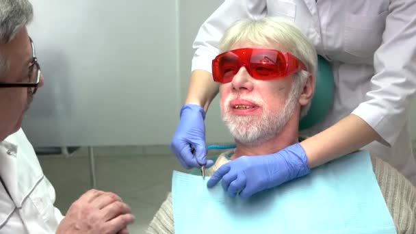 Dentistas con paciente de edad avanzada . — Vídeo de stock