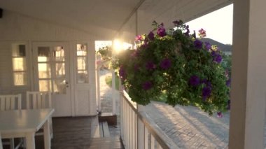 Çiçekler verandada asılı.