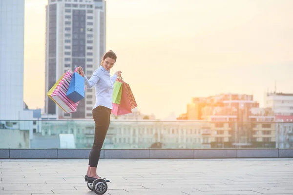 Kobieta z torby na zakupy, hoverboard. — Zdjęcie stockowe