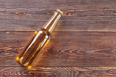 Şişe bira ahşap masanın üzerinde yatan.