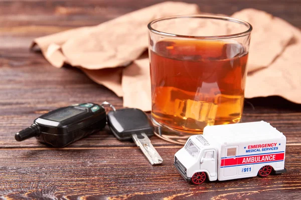 Alcohol, sleutels, ambulance, houten achtergrond. — Stockfoto