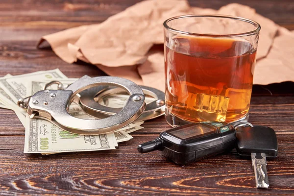 Whiskey, handboeien, auto sleutel, geld. — Stockfoto
