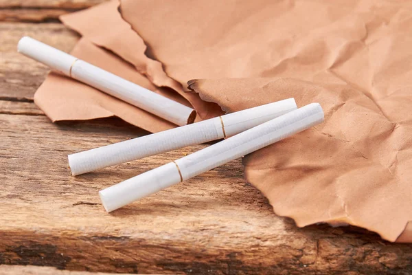Cigarros na borda do papel queimado. — Fotografia de Stock