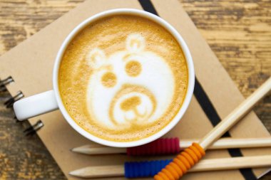 Kahve fincanı, defter ve kalemler.