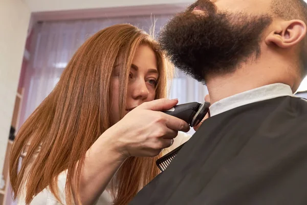 Barbeiro fêmea está cuidando da barba . — Fotografia de Stock