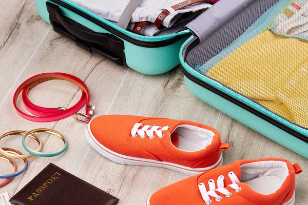 Zapatillas de color cerca de maleta abierta . — Foto de Stock