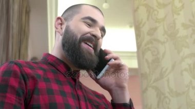 Telefon ile neşeli sakallı adam.