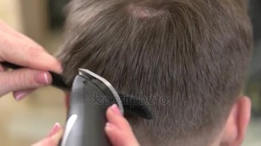 Saç kesme makinesi kullanarak eller.