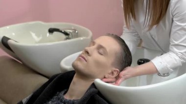 Adam kafasını elde yıkanır.