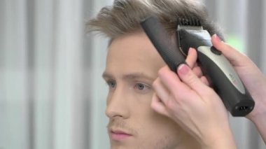 Saç kesimi, saç kesme makinesi kullanarak ele.