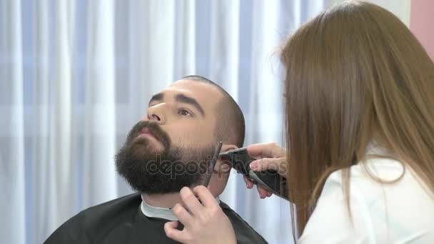 Female barber grooming beard. — Stock Video