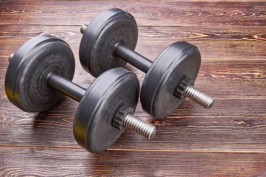 Eğitim dumbbells ahşap zemin üzerinde.
