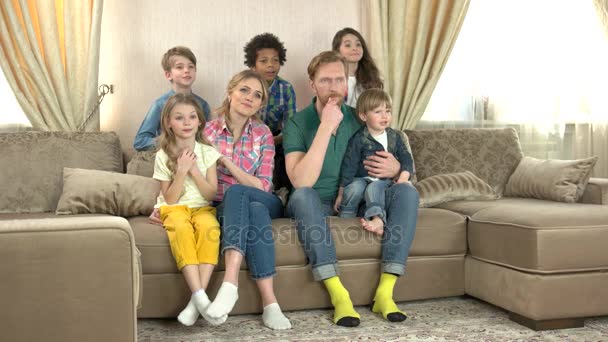 Ενθουσιασμένος οικογένεια κάθεται στον καναπέ. — Αρχείο Βίντεο