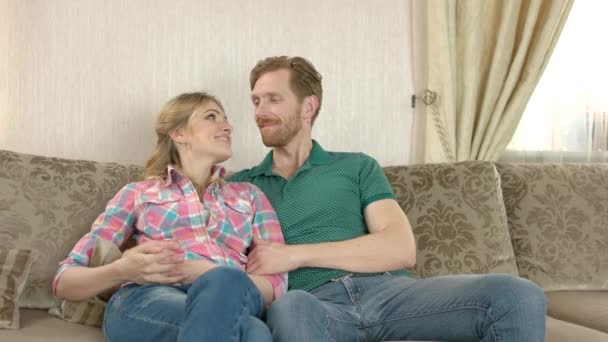 Sorrindo casal sentado no sofá . — Vídeo de Stock