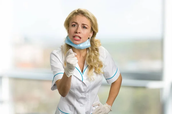 Angry young nurse pointing with finger. — Stock Photo, Image