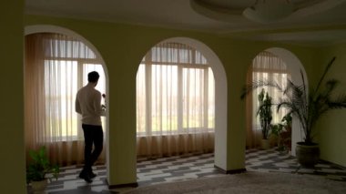 Adam holding çiçek pencere yakınındaki.