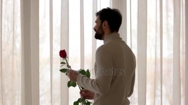 Beyaz adam gül tutan.