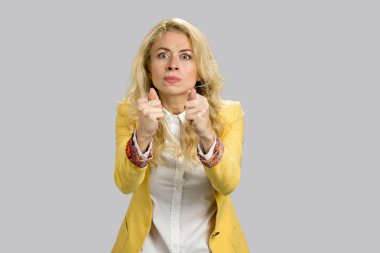 Başparmak ile gesticulating kızgın genç sarışın.