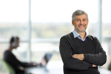 Çapraz silah ile gülümseyen olgun adam.