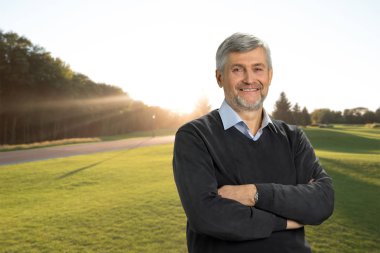 Doğa arka plan üzerinde gülümseyen olgun adam.