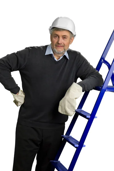 Contractor in helmet and gloves leaning on ladder. — Stock Photo, Image