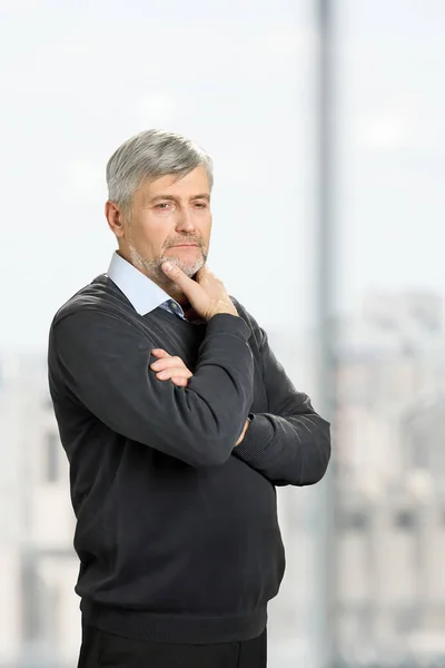 Thoughtful mature man on blurred background. — Stock Photo, Image