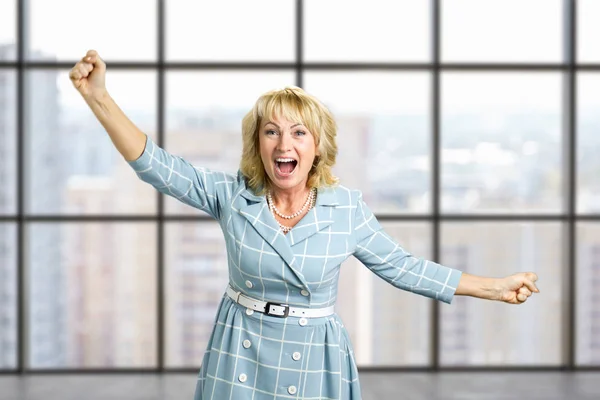 Excited mature woman clasping fists. — Stock Photo, Image
