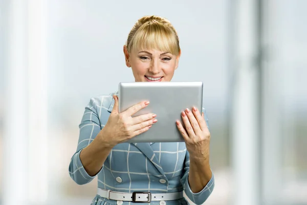 Smiling mature woman with pc tablet.