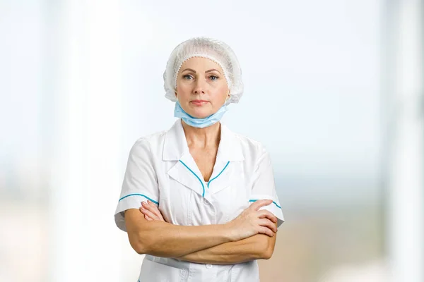 Female surgeon with crossed arms.