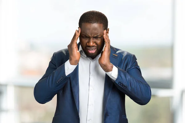 Jonge afro Amerikaans zakenman, hoofd aan te raken. — Stockfoto