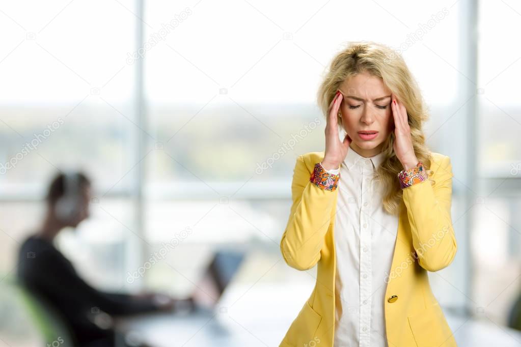 Young business woman with terrible headache.