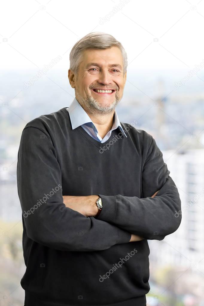 Cheerful mature man crossed arms.