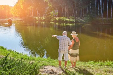 Yaşlı çift ayakta su yakınında.