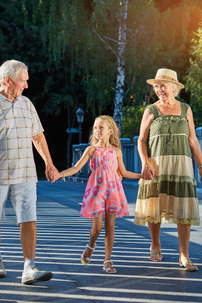 Ребенок с бабушкой и дедушкой на улице
.